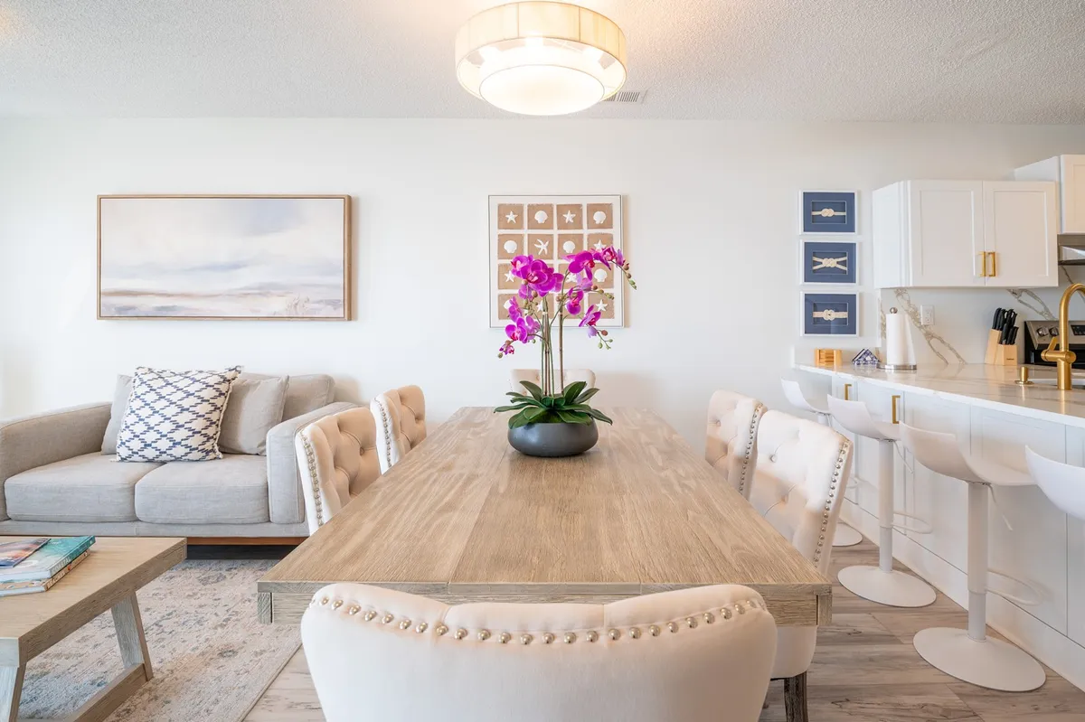 A stylish dining area featuring a table with a floral centerpiece, plush seating, and tasteful wall art. The space is designed for group meals, celebrations, and socializing, reflecting a balance between elegance and comfort.
