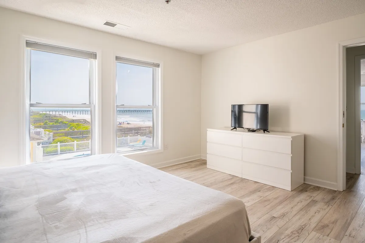 This image captures large windows framing a beautiful view of the nearby pier, paired with comfortable furnishings that invite relaxation and reflection. The scene connects interior comfort with the external draw of local attractions.